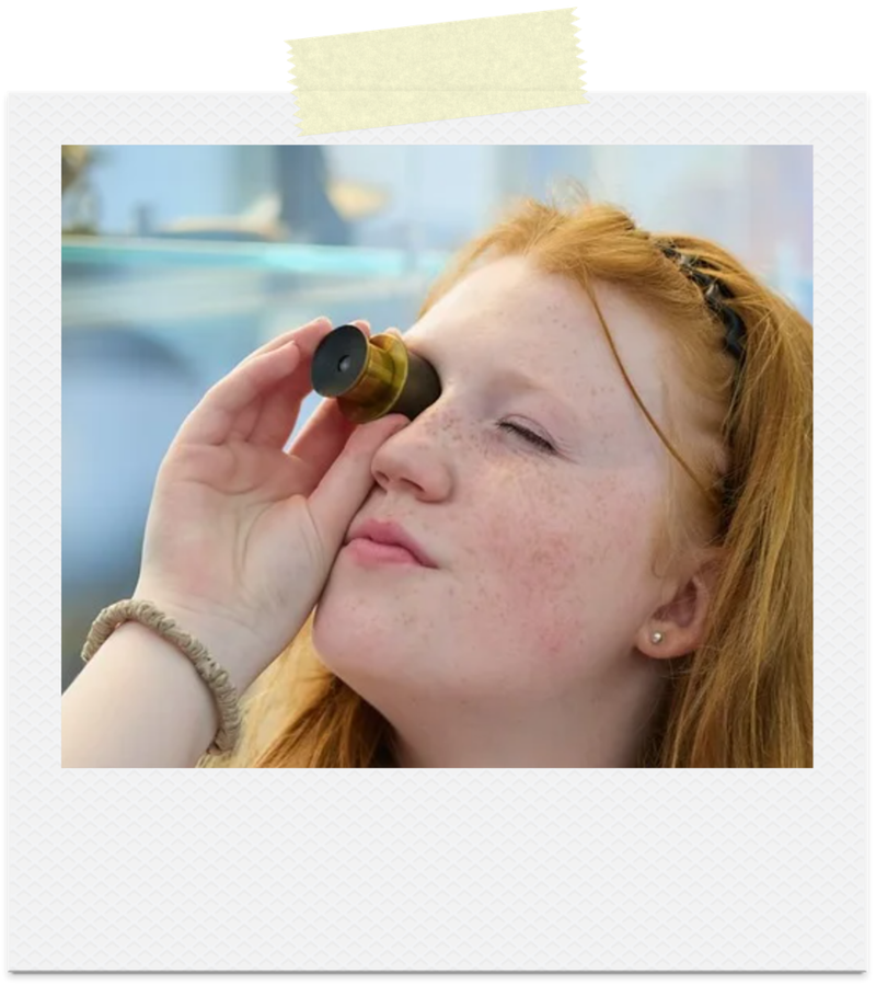 Young person looking through microscope