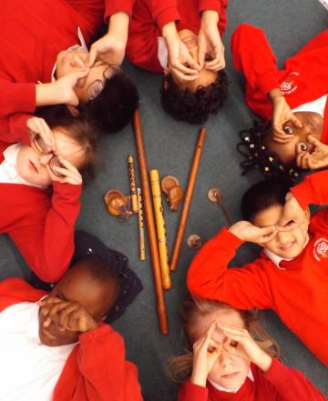 Story Makers' Eye Circle: a ring of children mimicking binoculars with their hands