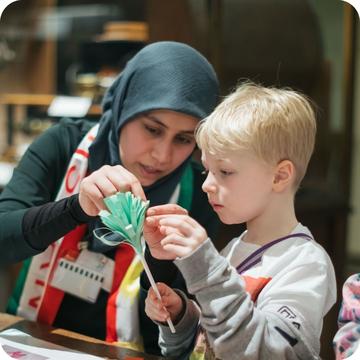 MultakaOxford volunteer working with a young child at an event MultakaOxford volunteer working with a young child at an event